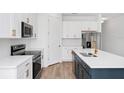 Bright kitchen featuring stainless steel appliances, white cabinets, and a spacious island at 2222 Derwent Dr, Davenport, FL 33896
