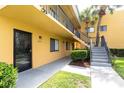 Apartment exterior showcasing stairs leading to the second floor, and a yellow painted finish at 2627 Oak Park Way # 102, Orlando, FL 32822