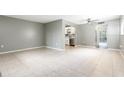 Open-concept living room with tile flooring, a ceiling fan, and a view of the kitchen at 2627 Oak Park Way # 102, Orlando, FL 32822