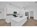 Modern kitchen showcasing white cabinets, a large island, and stainless steel appliances at 300 Cherokee Ave, Orange City, FL 32763