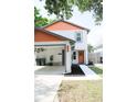 Charming two-story home with a carport, orange accents, and well-maintained landscaping at 312 W Hull Ave, Oakland, FL 34760