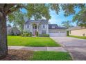 Charming two-story home boasts a well-manicured lawn, a three-car garage, and mature trees providing shade at 3231 Furlong Way, Gotha, FL 34734