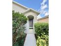 Inviting front entrance with a sheltered doorway and neatly trimmed bushes adding curb appeal to the home at 324 Charles Dr, Deland, FL 32724