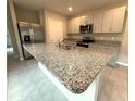 Modern kitchen featuring an island with a granite countertop, stainless steel appliances, and ample storage at 324 Charles Dr, Deland, FL 32724