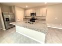Modern kitchen featuring an island with a granite countertop, stainless steel appliances, and ample storage at 324 Charles Dr, Deland, FL 32724