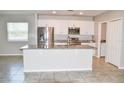 Bright kitchen with an island sink, stainless steel appliances, granite counters, and white cabinets at 3381 Sw 129Th Loop, Ocala, FL 34473
