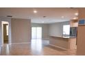Open-concept living space featuring tile flooring, neutral walls, and sliding glass doors to the backyard at 3381 Sw 129Th Loop, Ocala, FL 34473