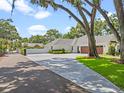 Long, paved driveway leading to a white farmhouse-style home with a three-car garage at 340 Lakeview Rd, Winter Garden, FL 34787