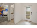 Inviting entryway showcasing a tiled floor, white door with obscured glass and adjacent bedroom at 4363 Scene Ln, Kissimmee, FL 34746