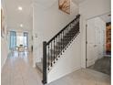 Bright entryway showcasing staircase with black railings, tile floors, and dining area at 4363 Scene Ln, Kissimmee, FL 34746