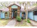 Home featuring a stone accented entrance with an arched window and a light blue exterior at 4933 Round Lake Rd, Apopka, FL 32712