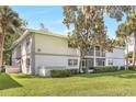 Exterior of the apartment building with a well-manicured lawn and mature trees at 563 Midway Trak # K102, Ocala, FL 34472