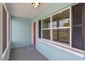 Inviting front porch with a vibrant red door and ample natural light at 588 Highway 630 E, Frostproof, FL 33843