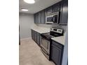 Kitchen featuring stainless steel appliances, tiled flooring, and painted cabinetry at 6108 Curry Ford Rd # 116, Orlando, FL 32822
