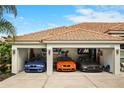 An open three-car garage showcasing sports cars with automotive decor, creating a haven for car aficionados at 6426 Montclair Bluff Ln, Windermere, FL 34786