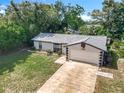 Aerial view of a single-story home with a well-maintained lawn and attached one car garage at 1089 Algoma St, Deltona, FL 32725
