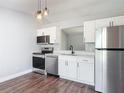 Modern kitchen with stainless steel appliances, white cabinets, and a new black sink and faucet at 1089 Algoma St, Deltona, FL 32725