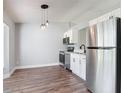 Open kitchen featuring modern stainless steel appliances, white cabinets, and hardwood floors at 1089 Algoma St, Deltona, FL 32725