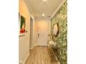 Inviting entryway features stylish wallpaper, decor table with mirror, and tile flooring at 14117 Larkspur Lake Dr, Winter Garden, FL 34787
