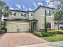 Charming two-story home featuring a three-car garage, landscaped yard, and classic architectural details at 14117 Larkspur Lake Dr, Winter Garden, FL 34787