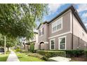 Attractive two-story house with manicured landscaping, featuring lush greenery and flowering plants along the sidewalk at 14215 Lakeview Park Rd, Winter Garden, FL 34787