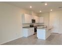 The kitchen has white cabinets, granite counters, stainless appliances, and an eat-in island at 1518 Isleta Loop, Kissimmee, FL 34741