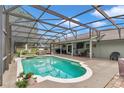 Screened-in pool area with a hot tub, outdoor seating, and a grill perfect for entertaining at 15650 Catherine Cir, Groveland, FL 34736