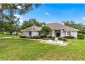 Well-maintained home with a manicured lawn, mature trees, and an inviting entrance at 1700 Shandwick Ct, Longwood, FL 32779