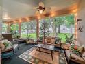 Enclosed lanai with comfortable seating, string lights, and views of the lush backyard at 1701 Lucky Pennie Way, Apopka, FL 32712