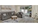 Comfortable living room with gray sofas, accent pillows, and sliding glass doors to the pool area at 17441 Hidden Forest Dr, Clermont, FL 34714