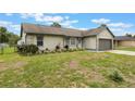 Inviting home with landscaped front yard, featuring stone details and an attached garage on a sunny day at 1785 6Th Ave, Deland, FL 32724