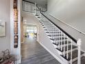 A grand entryway with hardwood floors, a staircase, and an inviting view of the backyard at 224 Hammock Dunes Pl, Orlando, FL 32828