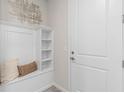 Inviting entryway featuring a built-in bench with storage, white wainscoting, and stylish decor at 2334 Daisy Tree Rd, St Cloud, FL 34771