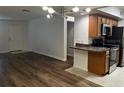 Bright living room with modern light fixture, wood floors, and adjacent kitchen at 3120 Plaza Terrace Dr # 3120, Orlando, FL 32803