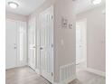 Bright hallway with multiple white doors and updated floors, providing access to rooms at 3187 Shady Willow Dr, Orlando, FL 32808