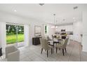 Open-concept dining area features a glass-top table, modern chairs, tile flooring, and access to the backyard at 33313 Country House Dr, Sorrento, FL 32776