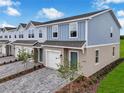 Desirable end unit townhome with blue siding, manicured lawn, and lush green landscaping at 3348 Thicket St, Tavares, FL 32778