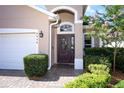 Close-up showcasing the front door with decorative glass, a paver walkway, and manicured landscaping at 4954 Alavista Dr, Orlando, FL 32837