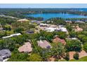 Aerial view of the home with a yellow border on a large property surrounded by lush trees and a lake at 5199 Latrobe Dr, Windermere, FL 34786