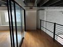 Loft area featuring hardwood floors, exposed brick, large windows and black metal railing at 62 W Colonial Dr # 302, Orlando, FL 32801