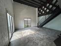Spacious loft featuring concrete floors, exposed brick, large window, black staircase, and wood ceiling at 62 W Colonial Dr # 302, Orlando, FL 32801
