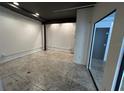 The empty room has a concrete floor, white walls, and black ceiling beams at 62 W Colonial Dr # 302, Orlando, FL 32801