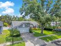 Overhead shot of a well maintained home boasting mature trees, nice landscaping, and a two-car garage at 651 Oak Hollow Way, Altamonte Springs, FL 32714