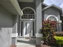 Close up front door of gray house with lots of glass and surrounding landscaped elements at 651 Oak Hollow Way, Altamonte Springs, FL 32714