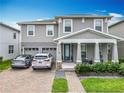 Charming two-story home with a well-manicured lawn, covered porch, and a two-car garage with brick paved driveway at 6947 Cucamelon Ct, Windermere, FL 34786