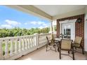 Relaxing balcony with outdoor seating and scenic views of the surrounding greenery and blue sky at 7616 Cabana Ct # 301, Reunion, FL 34747