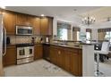 Well-lit kitchen featuring stainless steel appliances, granite countertops, and dark wood cabinets at 7616 Cabana Ct # 301, Reunion, FL 34747