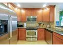 Well-equipped kitchen with stainless steel appliances, wood cabinets, and granite countertops at 7616 Cabana Ct # 301, Reunion, FL 34747