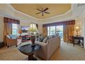 Bright living room features a comfortable sofa, stylish furnishings, and a sliding glass door leading to a balcony at 7616 Cabana Ct # 301, Reunion, FL 34747