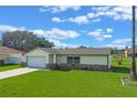 Exterior of the home with fresh lawn, featuring an attached two-car garage at 856 Mendoza Dr, Kissimmee, FL 34758